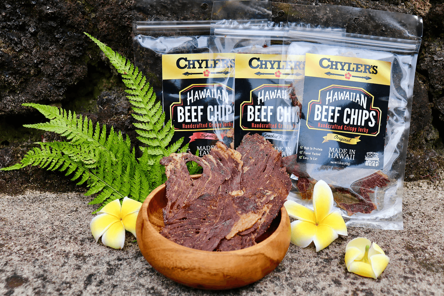 Chyler's Hawaiian Beef Chips with wooden bowl, plumeria flowers and ferns